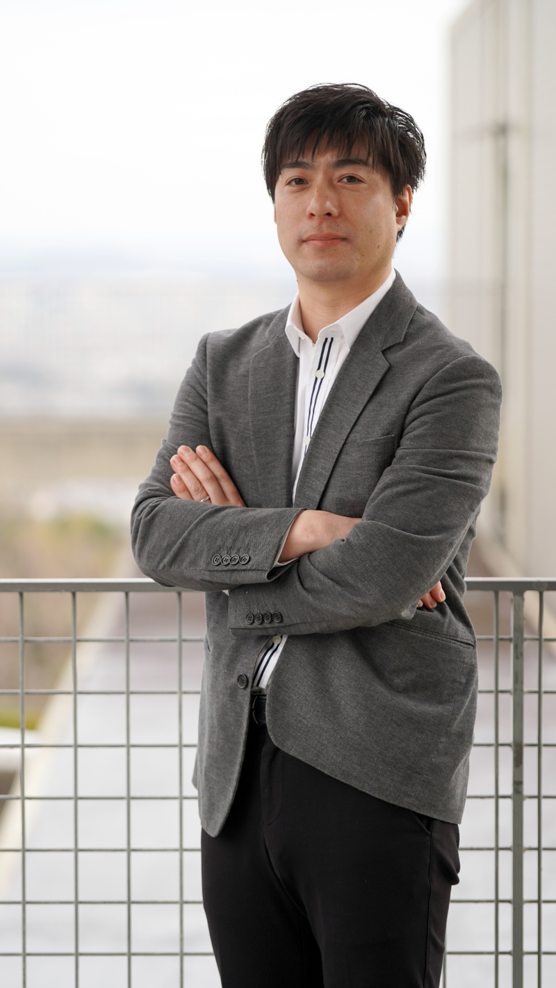 Yoshihiro Sejima stands outside with his arms crossed